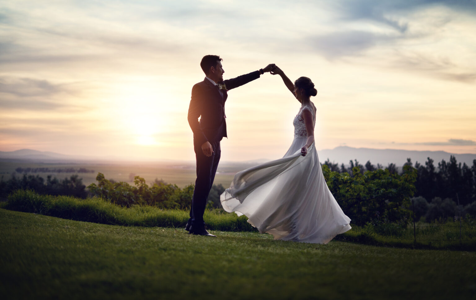 Shot of a happy young couple dancing outdoors at sunset on their wedding day